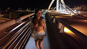 😏 luscious milf struts bra-less panty-free over the bridge, flashing those huge tits! 🔥