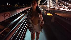 😏 luscious milf struts bra-less panty-free over the bridge, flashing those huge tits! 🔥