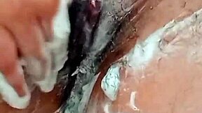 Young brunette shaves hairy pussy closeup in bathroom