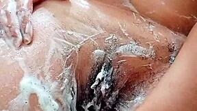 Young brunette shaves hairy pussy closeup in bathroom