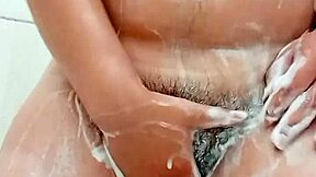 Young brunette shaves hairy pussy closeup in bathroom