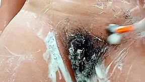 Young brunette shaves hairy pussy closeup in bathroom