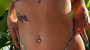 pretty brunette in tropical bikini dances in garden