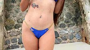 petite brunette flashes sexy body in tiny blue bikini on crowded beach