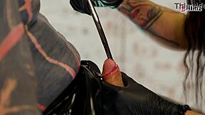 three latex femdoms dominate a tattooed slave
