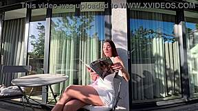 Wonderfully beautiful girl in a summer dress no panties on the balcony shows her tight shaved pussy to the neighbors