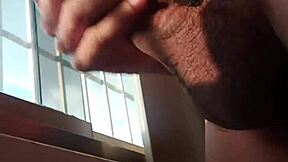 dude, check this hot guy with a big dick jerking off in public by the window!