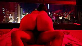 chubby brunette sits for big black dick in red light scene.