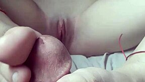 Petite babe gives footjob while masturbating.