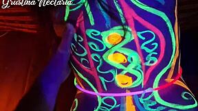 Wild slim brunette girl with long hair gets fucked doggystyle by big cock in UV light.