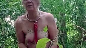 Slave maid in bondage gets handcuffed and fucked doggystyle with dildo in public outdoor humiliation.