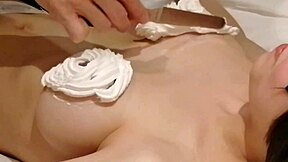 Amateur homemade video where I craft a cream-decorated bra on my busty girlfriend's breasts in bedroom.