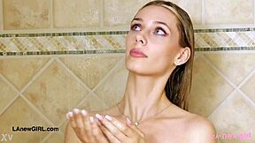 Stunning golden-haired model takes a shower after photoshoot on sofa with petite body