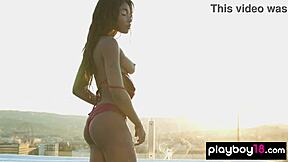 Ebony teen Mimi Desuka smokes a cig while stripping big natural tits on sunny rooftop unwind