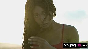 Ebony teen Mimi Desuka smokes a cig while stripping big natural tits on sunny rooftop unwind