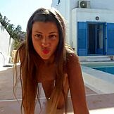 Jovem beleza Melena Maria esguichando na piscina em brincadeira solo