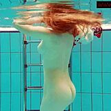 kosmata rdečelaska Poljakinja mlada ženska plava gola v bazenu